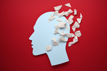 Brain disorder symbol presented by human head made form crumpled paper torn on red background.