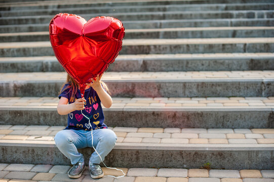 The little girl with an inflatable red heart