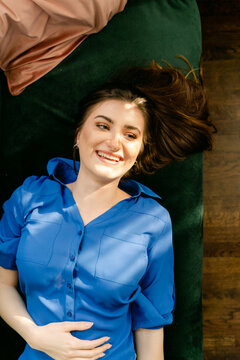 happy young woman lying down on sofa in the  sun   