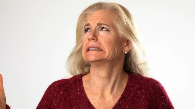 Closeup portrait of angry, scared, confused senior mature middle age woman put hands out ask why me, isolated on white background studio. People lifestyle emotions concept. 