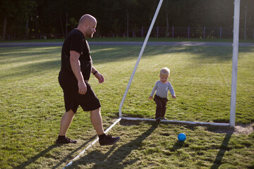 father and son playing football