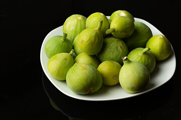 Higos verdes sobre fondo negro.