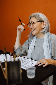 Elderly female calligrapher creating calligraphy works