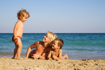 Happy family enjoying the summer beach - lots of copy space