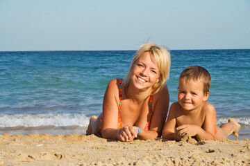 Smiling woman and boy on the beach