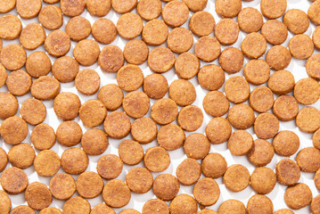 Small, round kibble on a white background.  Pet food bites or small training treats.