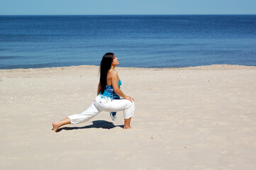 attractive brunette woman doing exercise on the beach