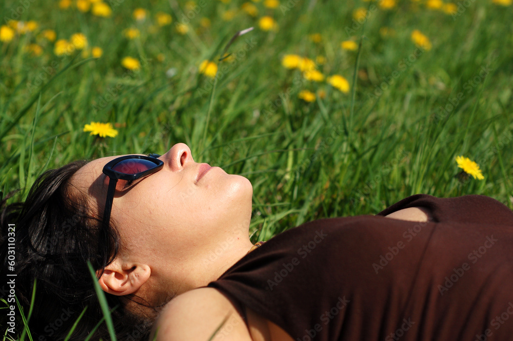 Poster attractive woman relaxing on green grass