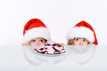 Kids lurking to get a glimpse of santa, having gingerbread cookies as bait - on white background