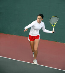 A pretty asian teenage girl playing tennis
