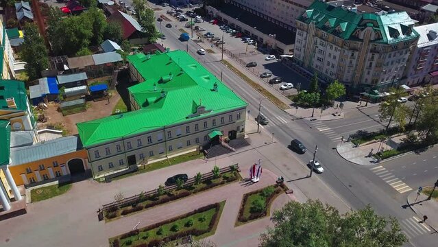 Aerial top down view of cars driving on street. Clip. Urban landscape with buildings and streets.
