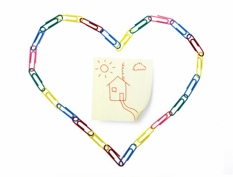 Symbolic sticky note with home inside the heart made of paper clips
