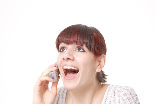 Closeup portrait of a happy young woman yealing on the phone isolated on white background