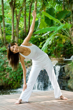 A young woman doing yoga outside in natural environment