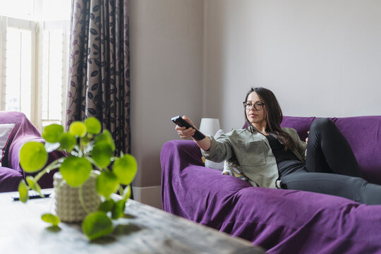 Woman switching channels with remote control