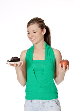 Cute Caucasian woman trying to make a decision between eating healthy or not