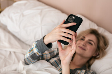Home: Woman In Bed Checks Smart Phone After Waking