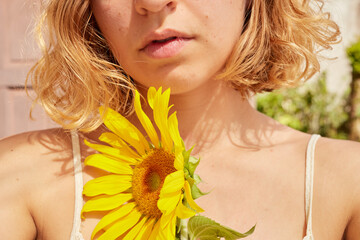Woman with a sunflower in a sunny day