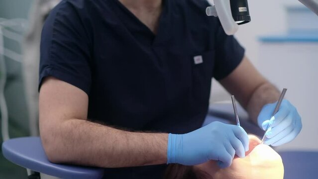 Professional dentistry services in clinic doctor in disposable gloves holding closeup of sterile dental tool for female patient teeth treatment woman ready for procedure