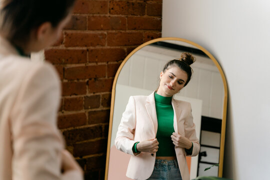 young confident  woman getting ready looking at reflection in mirror 