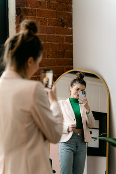 young woman taking selfie in mirror