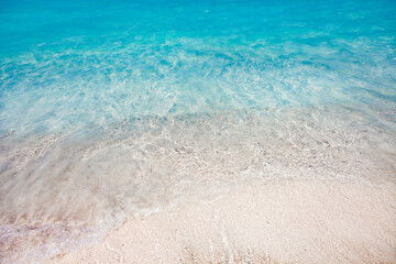 Sea surf with clear turquoise water on a sandy beach