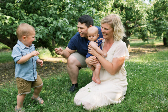 Happy smiling family with baby and toddler outdoors in summer