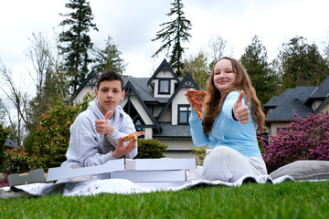 teenagers couple of young people together at picnic boys girl drumming dancing sitting on plaid in private sector on grass pizza boxes show class thumb smile pizzeria advertisement delicious food