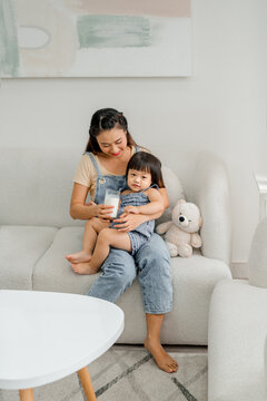 Mom and little girl holding milk glasses and drink to get calcium
