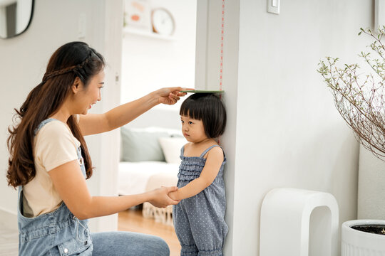 mother measures the growth of her daughter