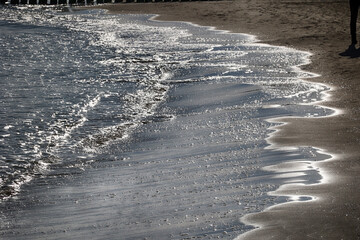 Nadmorska plaża o zachodzi słońca z falami wody. 