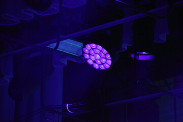 Violet spotlight on top stage light in darkness - obrazy, fototapety, plakaty