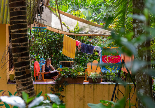 Woman Writing in journal in tropical backyard 