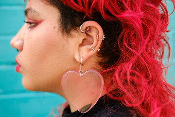 Profile of non-binary person with pierced ear and red hair 