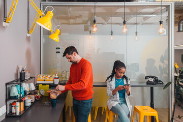 Young man preparing a coffee in cozy office kitchen