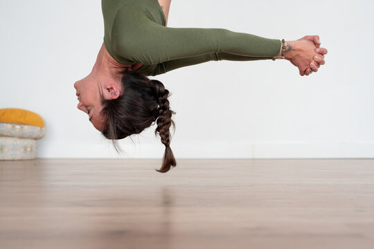 Woman performing aerial yoga pose in studio