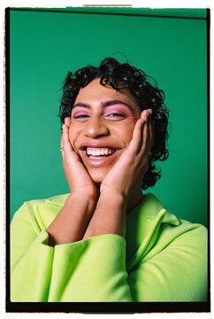 Happy extravagant male laughing against white background