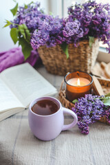 Cup of tea, straw hat and lilac basket, spring still life