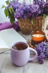 Cup of tea, straw hat and lilac basket, spring still life