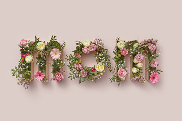 Word MOM of spring flowers inside cardboard boxes.