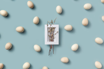 Willow catkins in frame with wooden Easter eggs.