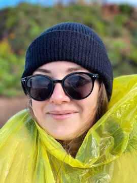Young woman portrait, woman in yellow slicker raincoat and  beanie hat