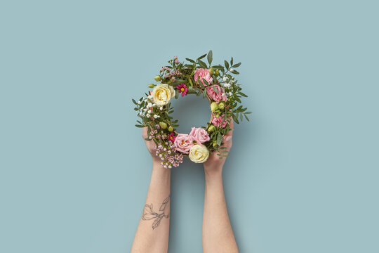 Bouquet in ring-shaped paper box held by woman.