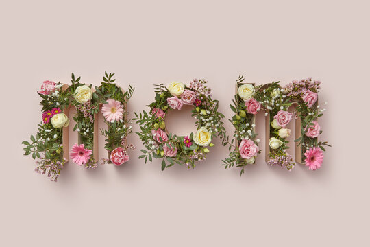 Word MOM of spring flowers inside cardboard boxes.