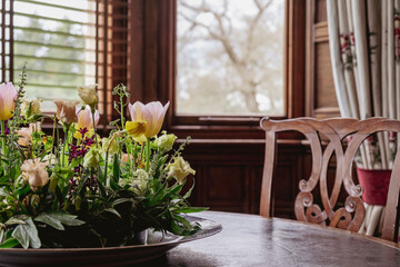 Spring blooms on a vintage wooden table with a window background