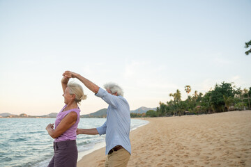 Cheerful Senior Couple Dancing In The Beach