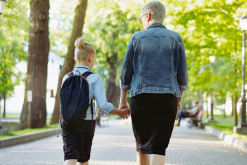 Fototapeta premium mother and son going to school holding hands