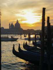 Venezia, Italia, vista del tramonto, sullo sfondo la basilica di Santa Maria della Salute dal molo di Piazza San Marco, con gondole e laguna in primo piano © Jacopo