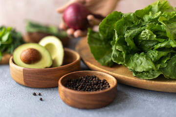 Lettuce, avocado and black pepper on a gray background. The concept of vegetarian food, healthy lifestyle and nutrition