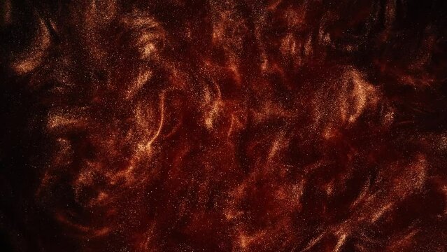 Glitter ink background. Paint mix. Volcanic eruption. Hot lava leak. Defocused orange golden color glow shiny wet fluid motion abstract texture shot on RED Cinema camera.